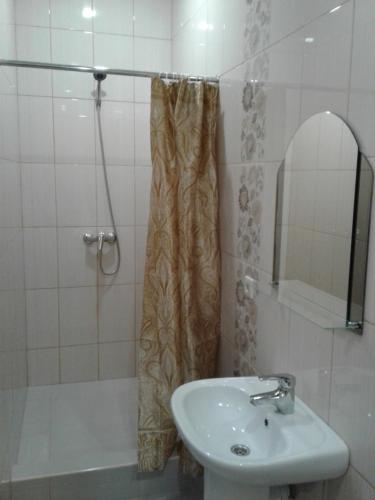 een badkamer met een wastafel, een douche en een wastafel bij Svetlana in Gelendzjik