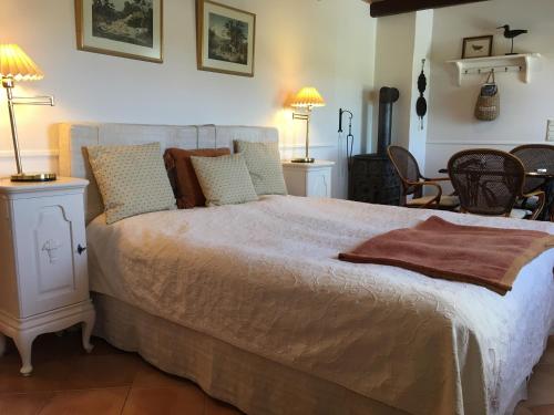 a bedroom with a large bed with two lamps at Rosengave in Alsted