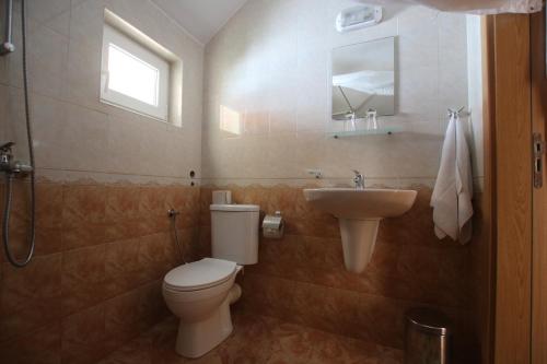 a bathroom with a toilet and a sink at Guest House Kiwi in Golden Sands