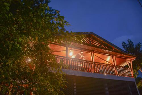 a house with a balcony with lights on it at Sinharaja Forest Gate in Deniyaya