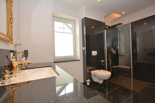 ein Badezimmer mit Waschbecken, Toilette und Dusche in der Unterkunft Ferienhaus Merzijana in Büsum