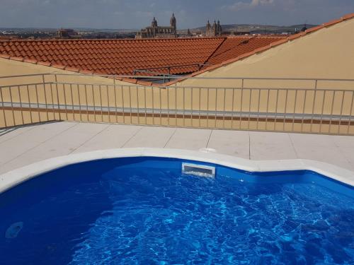 a large blue swimming pool on top of a building at Hotel Alameda Palace in Salamanca