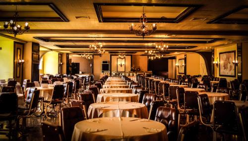 uma fila de mesas e cadeiras num salão de banquetes em Dom Pedro I Palace Hotel em Foz do Iguaçu