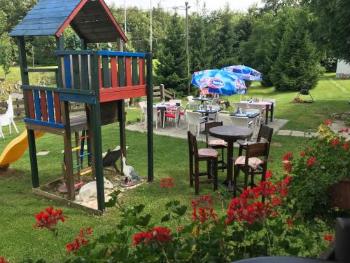 a garden with a play tower and tables and chairs at Pansion Danica in Rastovača