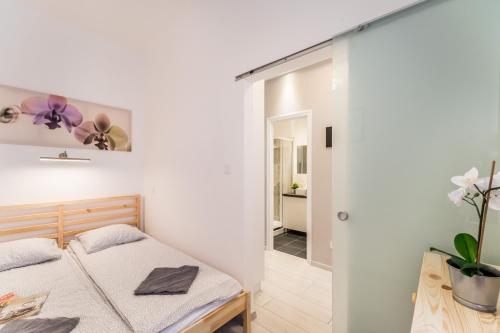 ブダペストにあるFleur Créme Apartmentの小さなベッドルーム(ベッド1台付)、廊下が備わります。