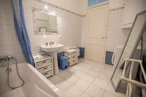 La salle de bains est pourvue d'un lavabo et d'une baignoire à côté d'un lavabo. dans l'établissement Bohemian Apartment by Connexion, à Cannes