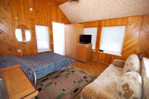 ein Schlafzimmer mit Bett, Sofa und Fenstern in der Unterkunft Aurada in Palanga