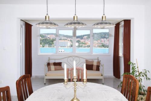 a dining room with a table and chairs and a window at Villa Merica in Trogir
