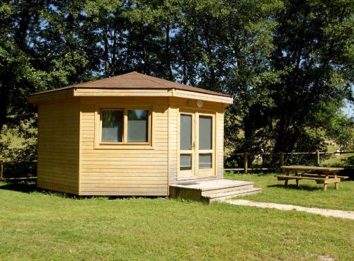 a small cabin in the grass with a picnic table at Le Petit Robinson in Champvert