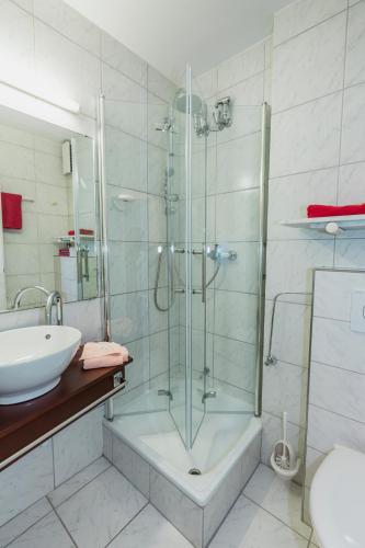 a bathroom with a glass shower and a sink at Hotel Excelsior in Kassel