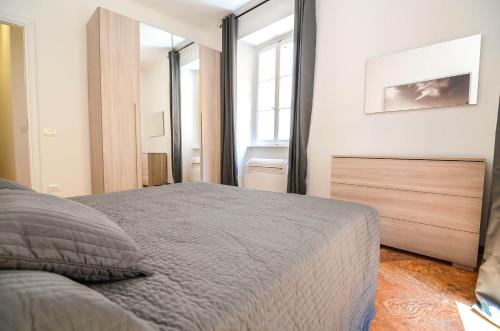 a bedroom with a bed and a large window at Bellagio Apartment in Bellagio