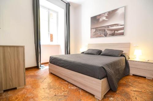 ein Schlafzimmer mit einem Bett und einem großen Fenster in der Unterkunft Bellagio Apartment in Bellagio