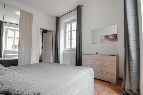 a bedroom with a bed and a dresser and a mirror at Bellagio Apartment in Bellagio