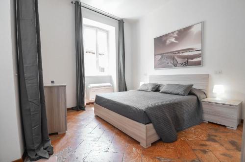 a bedroom with a bed and a large window at Bellagio Apartment in Bellagio