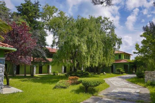 una casa verde con un árbol en el patio en İstanbul Airport Durusu Club Hotel, en Arnavutköy