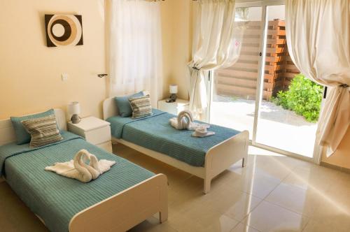2 Betten in einem Zimmer mit Schwänen darauf in der Unterkunft Villa Olivia, Coral Bay in Coral Bay