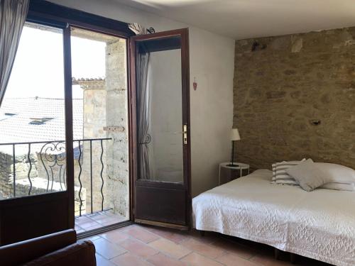 SernhacにあるProvence Hausのベッドルーム1室(ベッド1台付)、バルコニーへの開放ドアが備わります。