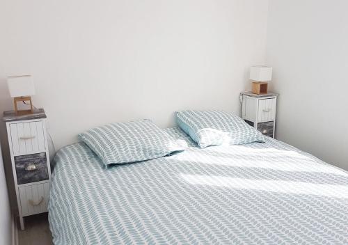 une chambre avec un lit avec deux tables de nuit et deux lampes dans l'établissement Le Rallye Royan, à Royan