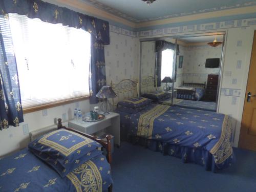 a bedroom with two beds and a mirror at Fantasia in Leven-Fife