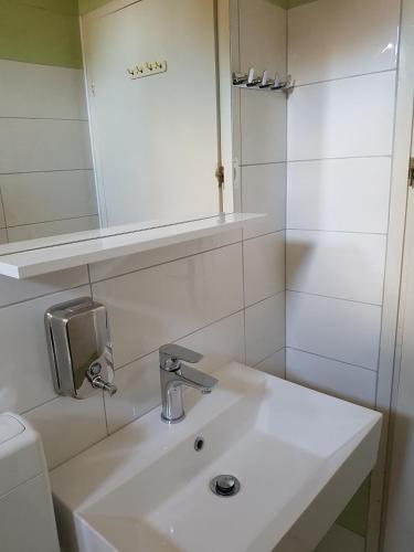 a white bathroom with a sink and a mirror at Apartments Eufemija in Novalja