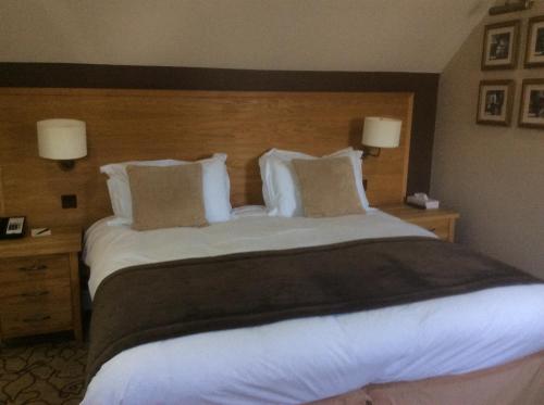 a large bed in a hotel room with two lamps at The New Inn in Cerne Abbas