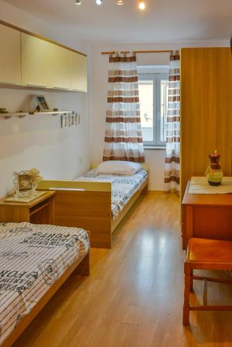 a small bedroom with two beds and a window at Apartman Pio in Senj