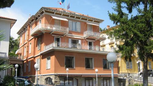 a large orange building with a balcony at Hotel Villa Maria in Sanremo