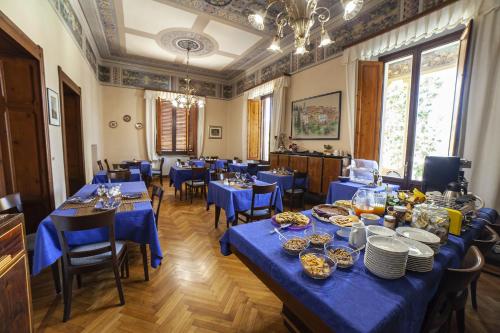 a large dining room with blue tables and chairs at Villa Moorings in Barga