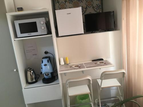a small kitchen with a microwave and a stove at La Corte del Re Borbone in Caserta