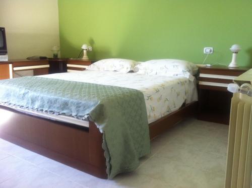 a bedroom with a bed with a green wall at la casa per le tue vacanze in Milazzo