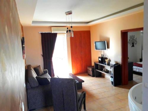 a living room with a couch and a tv at Maya Bay in Kallithea Halkidikis