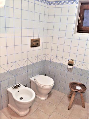 a blue tiled bathroom with a toilet and a bidet at Case Vacanza Al Borgo Antico in Vico del Gargano