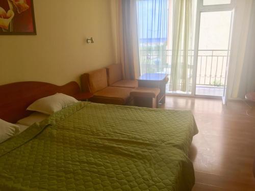 1 dormitorio con 1 cama, 1 silla y 1 ventana en Hotel Elmaz en Lozenets
