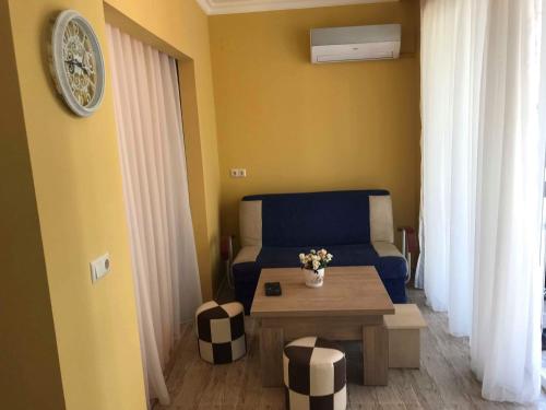 uma sala de estar com um sofá azul e uma mesa em Griboedovi N.6 em Batumi