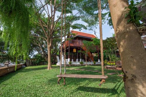 a swing in a yard in front of a house at Phuttal Residence in Phra Nakhon Si Ayutthaya