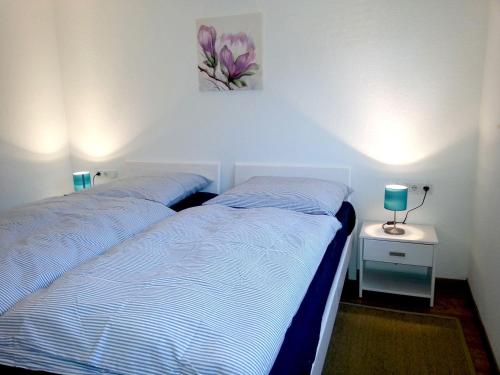 メーデバッハにあるFeWo-Tannenhofのベッドルーム1室(ベッド2台、ランプ付きテーブル付)