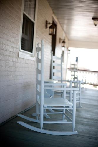 a group of white chairs sitting on a porch at Hopkins Ordinary Bed, Breakfast and Ale Works in Sperryville