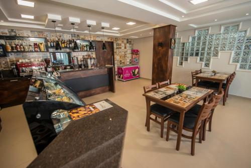 a restaurant with a table and chairs and a bar at Hotel Castelo in Gravatal