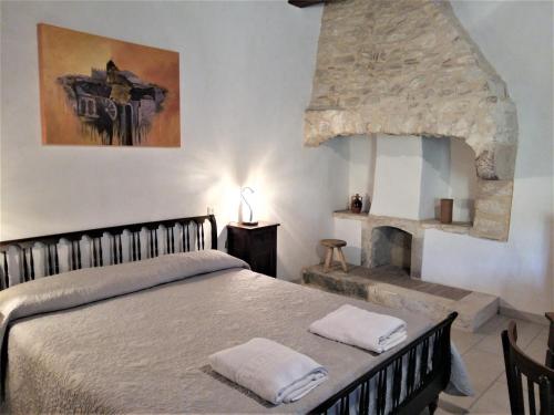 a bedroom with a bed and a stone fireplace at Case Vacanza Al Borgo Antico in Vico del Gargano