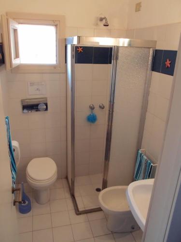 a bathroom with a shower and a toilet and a sink at Casa Gialla in Costa Paradiso