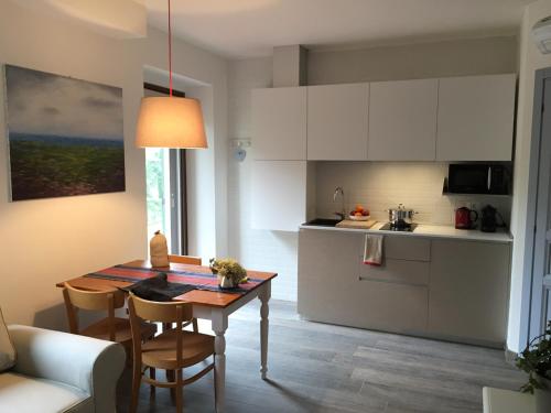 Il Colle delle Terrazze في فانو: مطبخ وغرفة طعام مع طاولة وكراسي