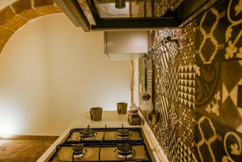 a kitchen with a stove top in a room at LA CARRETTERIA, ospitalità siciliana in Avola
