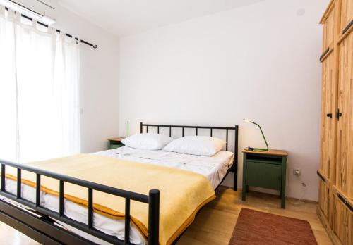 a bedroom with a bed and a table and a window at Apartments Jankovic in Biograd na Moru