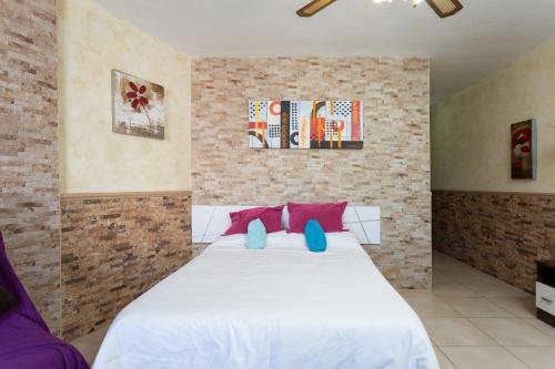 アロナにあるParque Santiago 2 apartamento 410のベッドルーム1室(ピンクとブルーの枕が付いた白いベッド1台付)