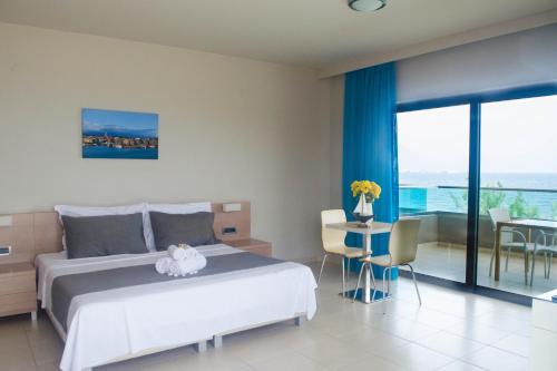 a bedroom with a bed and a table with chairs at Nautilus Bay Hotel in Kissamos