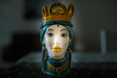 a bottle with a face with a crown on its head at LA CARRETTERIA, ospitalità siciliana in Avola