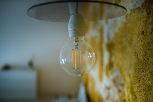 a glass light bulb hanging from a wall at LA CARRETTERIA, ospitalità siciliana in Avola