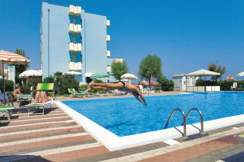 una persona che salta in una piscina di Hotel Atlantic a Rimini