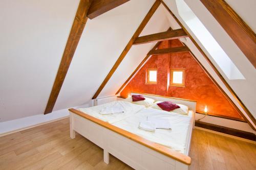 a bedroom with a white bed in a attic at Vila Johanka & Apartments in Český Krumlov