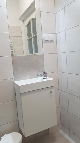 a white bathroom with a sink and a mirror at Rysiówka in Poronin